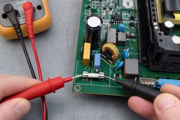 PCB fuse continuity testing with multimeter probes on a de-energized board