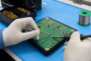 Production jumper installation during PCB assembly with controlled wire routing and soldering