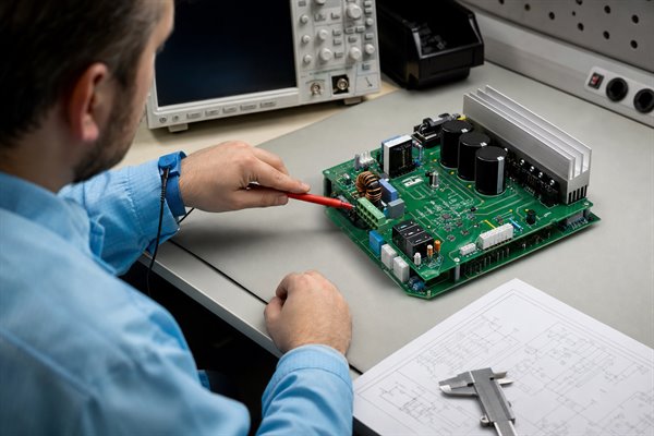 Engineer reviewing the rectifier and DC-link input stage of a motor control PCB