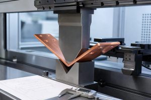 Copper busbar being bent in a precision press brake