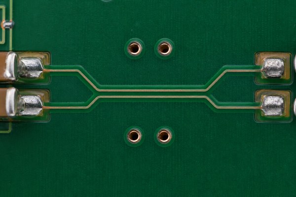 Differential pair PCB, paired copper traces routed symmetrically between pads and vias