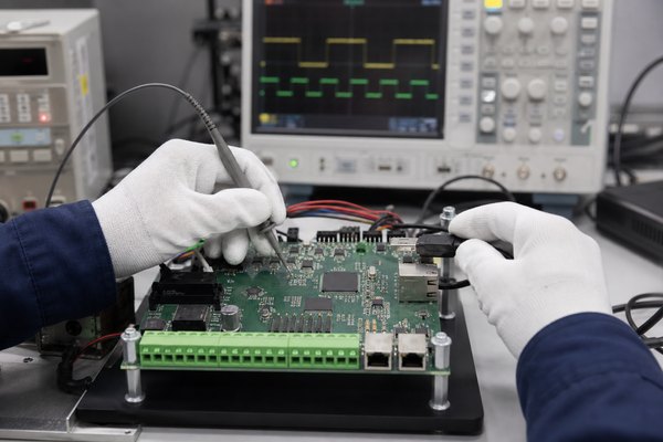 Industrial microcontroller PCB validation with oscilloscope probes and test fixture