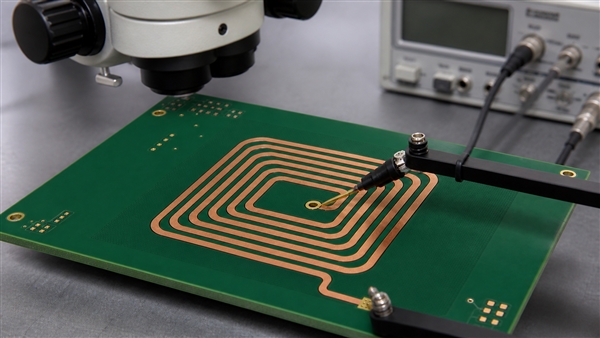Illustrative microscope and terminal-probe setup for checking a printed coil