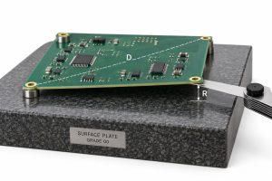 PCB twist measurement showing board diagonal D and raised corner gap R on a precision surface plate
