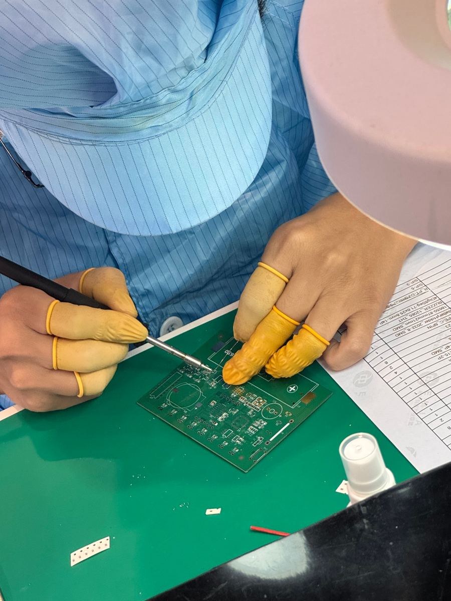Close-up of manual PCB soldering during the QUICK Cup competition